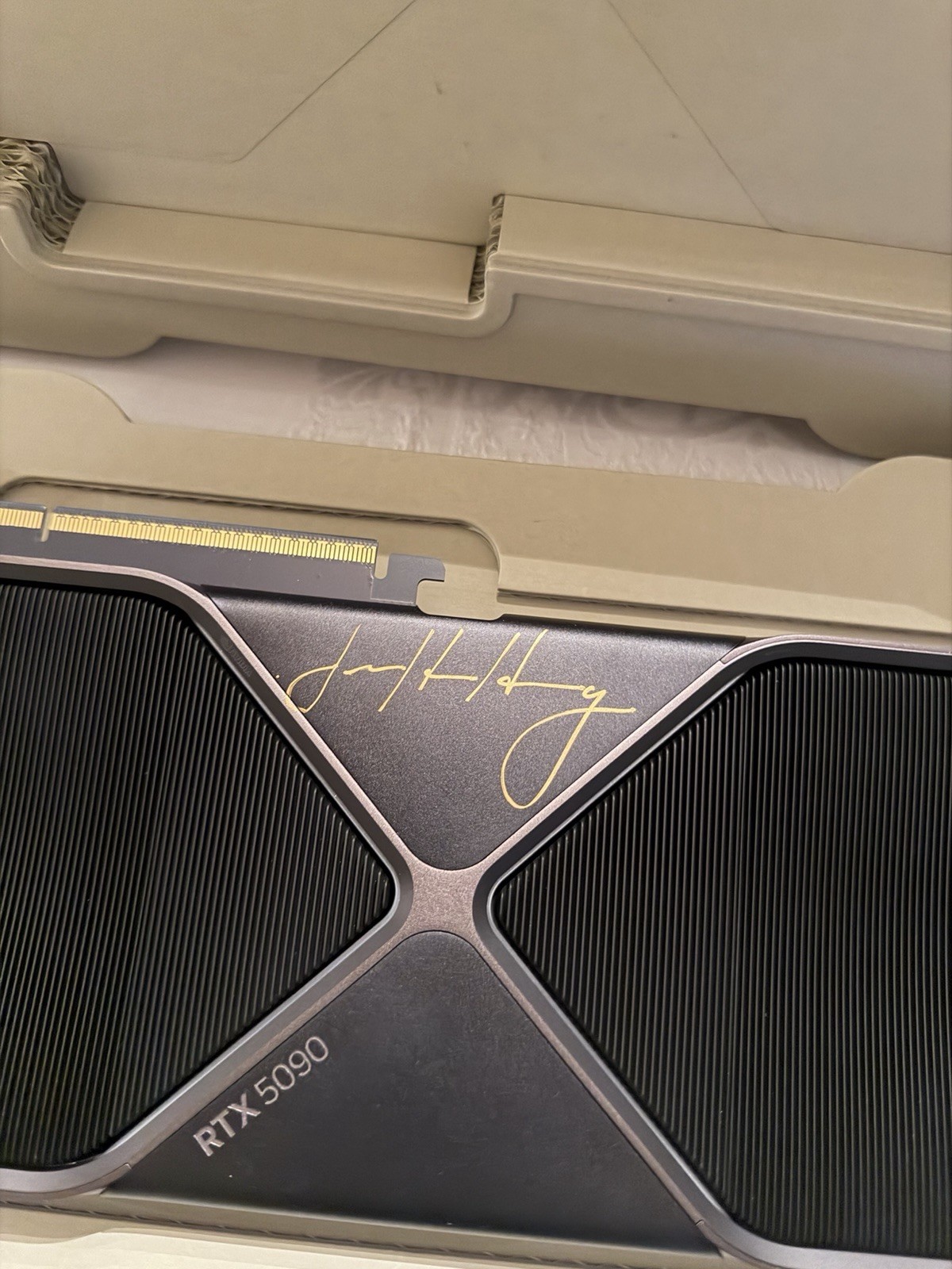 Close-up of the Jensen Huang autograph in gold ink on the NVIDIA GeForce RTX 5090 Founders Edition